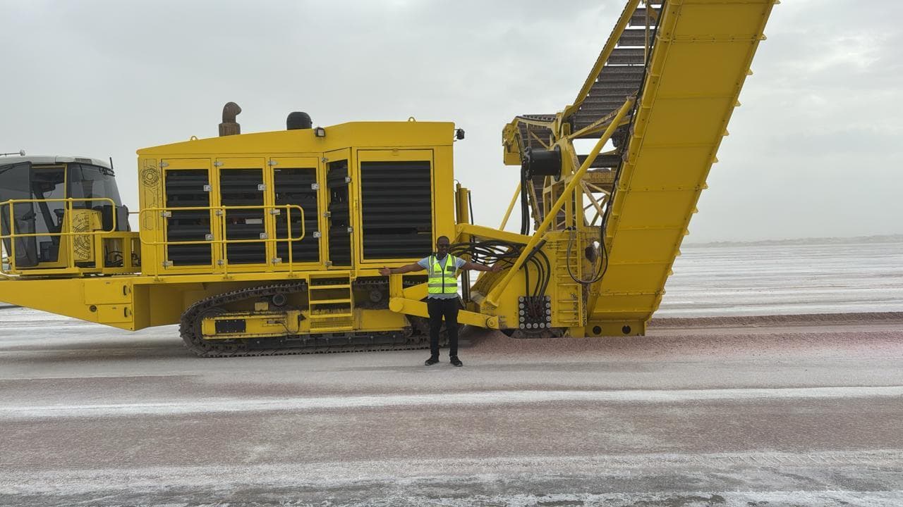 Full side view of the yellow salt harvester with its conveyor raised during testing
