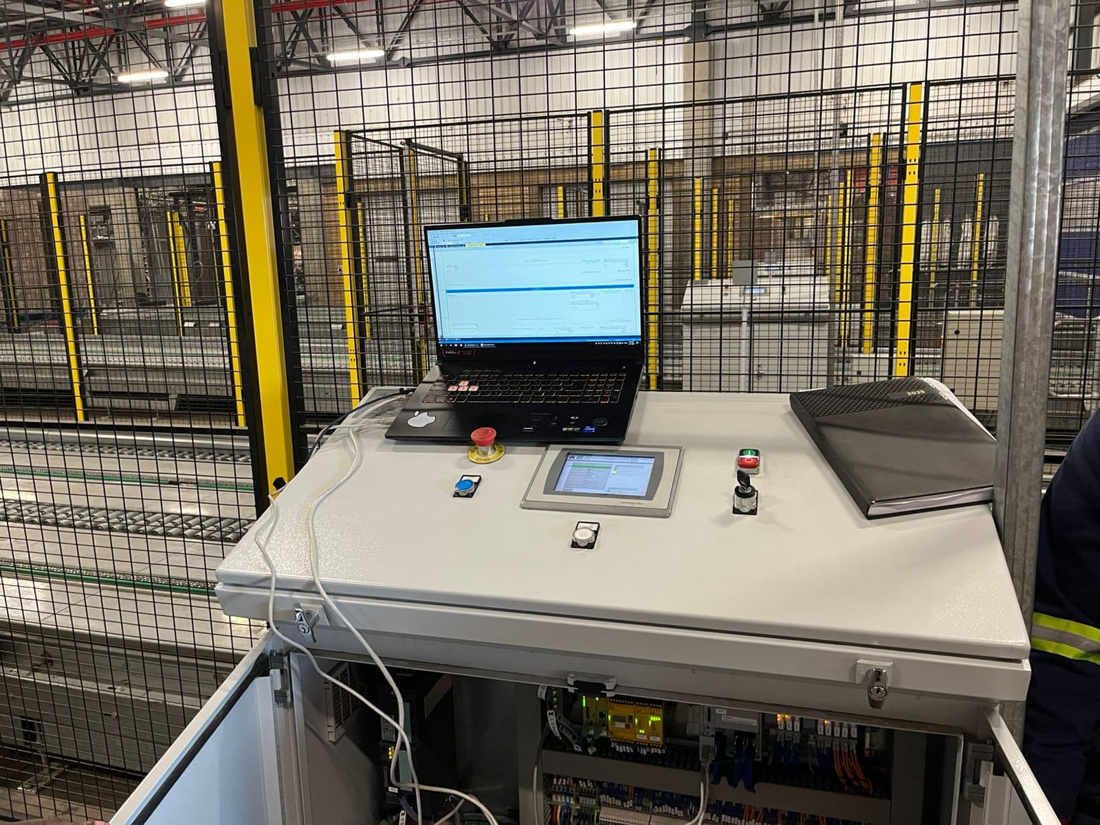Commissioning station beside guarded assembly lines in an automotive plant.