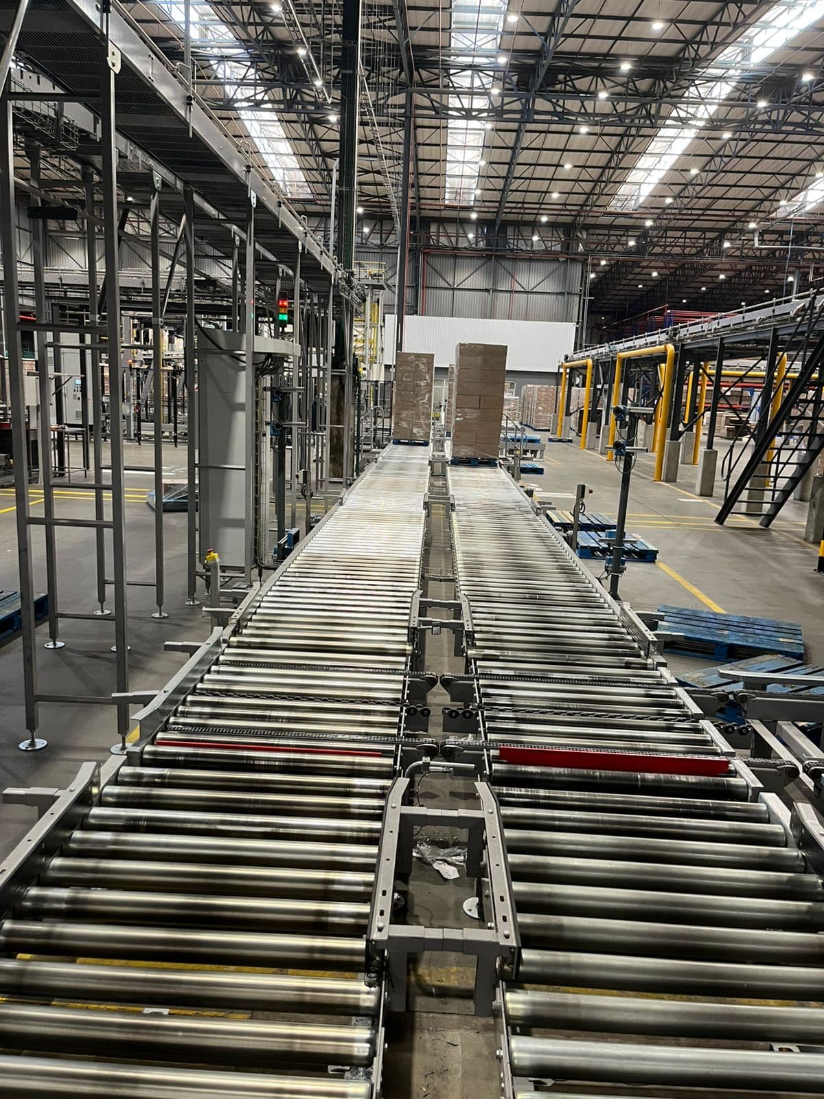 Roller conveyor and pallet handling line running the length of a distribution warehouse.