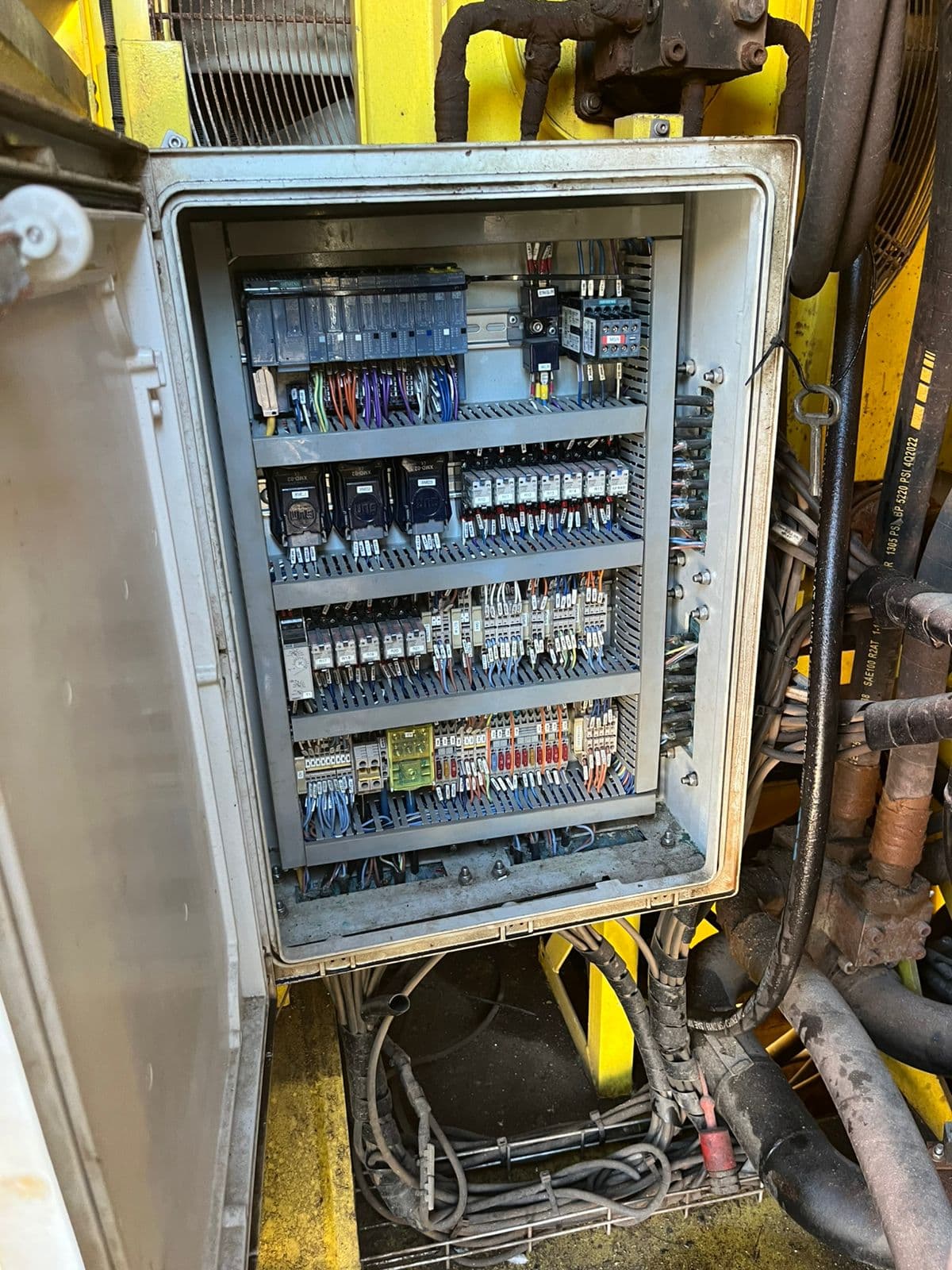 Retrofitted control enclosure on a yellow mining machine, with new Siemens ET 200 distributed I/O installed into the existing frame.