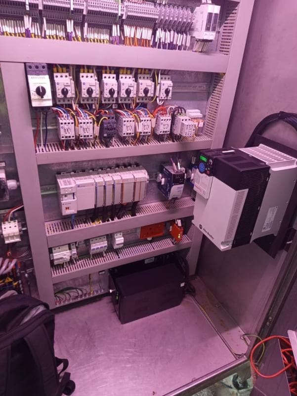 Re-wired control panel showing PLC modules, contactors and a variable speed drive