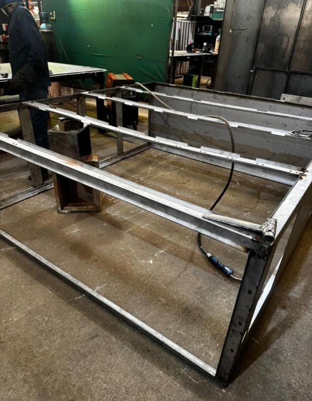 Welded steel enclosure frame viewed from the side