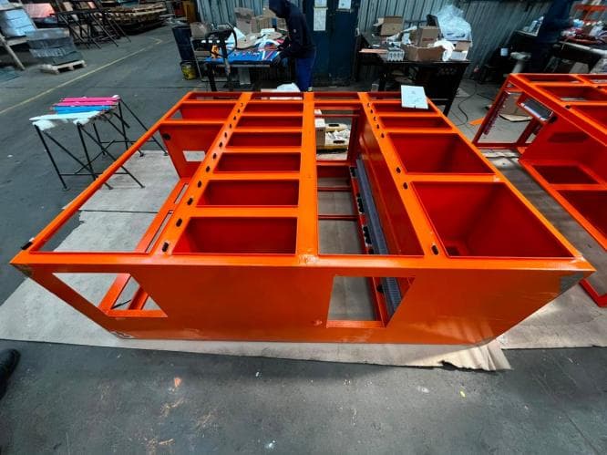 Orange powder coated panel frame on the workshop floor