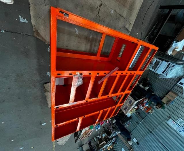 Orange powder coated panel frame standing on its side