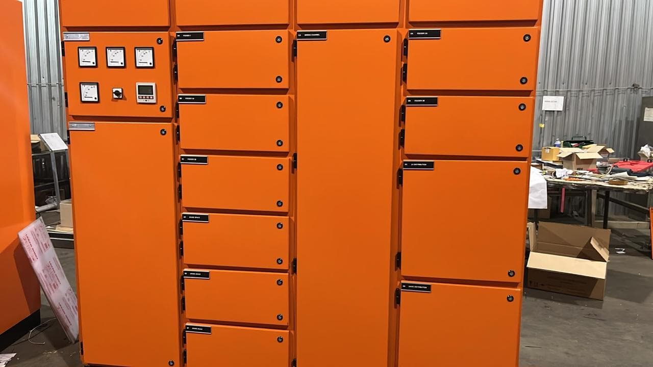 Close view of the finished orange feeder panel showing meters, selector switch and labelled compartments