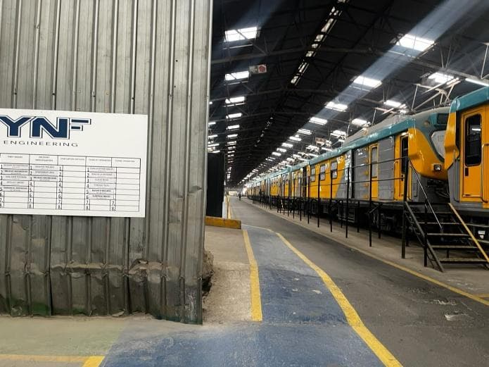 YNF Engineering signage beside a workshop bay with passenger carriages